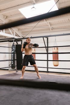 Man practicing boxing in a gym with gloves; focused training session.