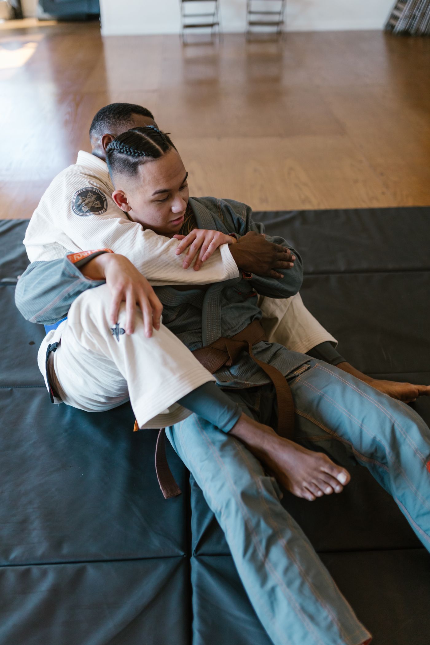 Two adults grappling on the mat during a Brazilian Jiu-Jitsu class
