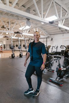 An athletic adult standing confidently in a gym, ready for a workout, wearing exercise attire.