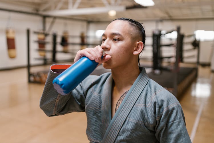 A Man Drinking On A Reusable Water Bottle