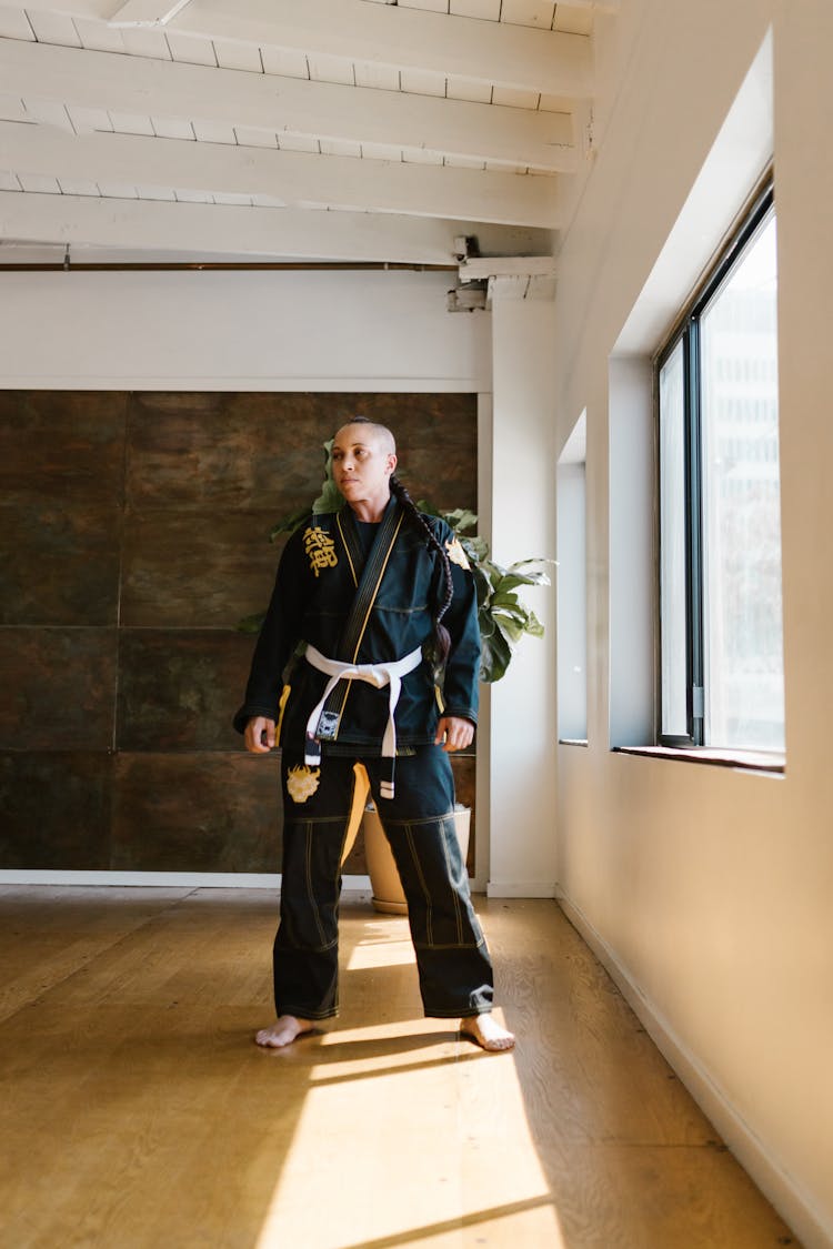 Woman Wearing Karate Uniform Standing Near Glass Windows