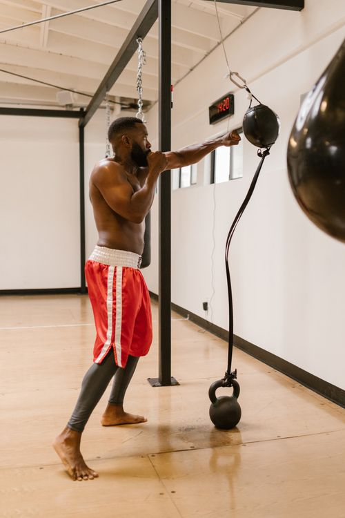 Free A determined man in sportswear practices boxing indoors, showcasing athleticism and focus. Stock Photo