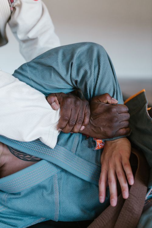 Free Detailed close-up of a jiu jitsu technique with hands gripping a gi, showcasing martial arts discipline. Stock Photo