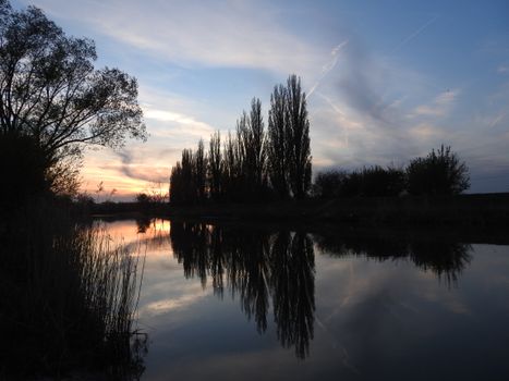 Peaceful scene of a sunset reflecting on a river in Nitra, Slovakia.