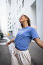Woman in Blue Crew Neck T-shirt and Brown Skirt Standing on Sidewalk