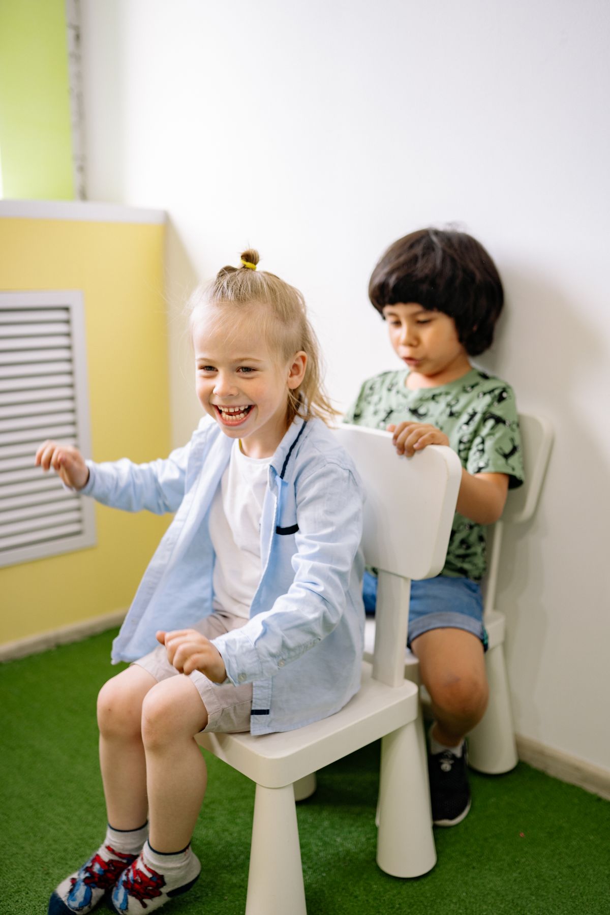 Two children laughing in a classroom.