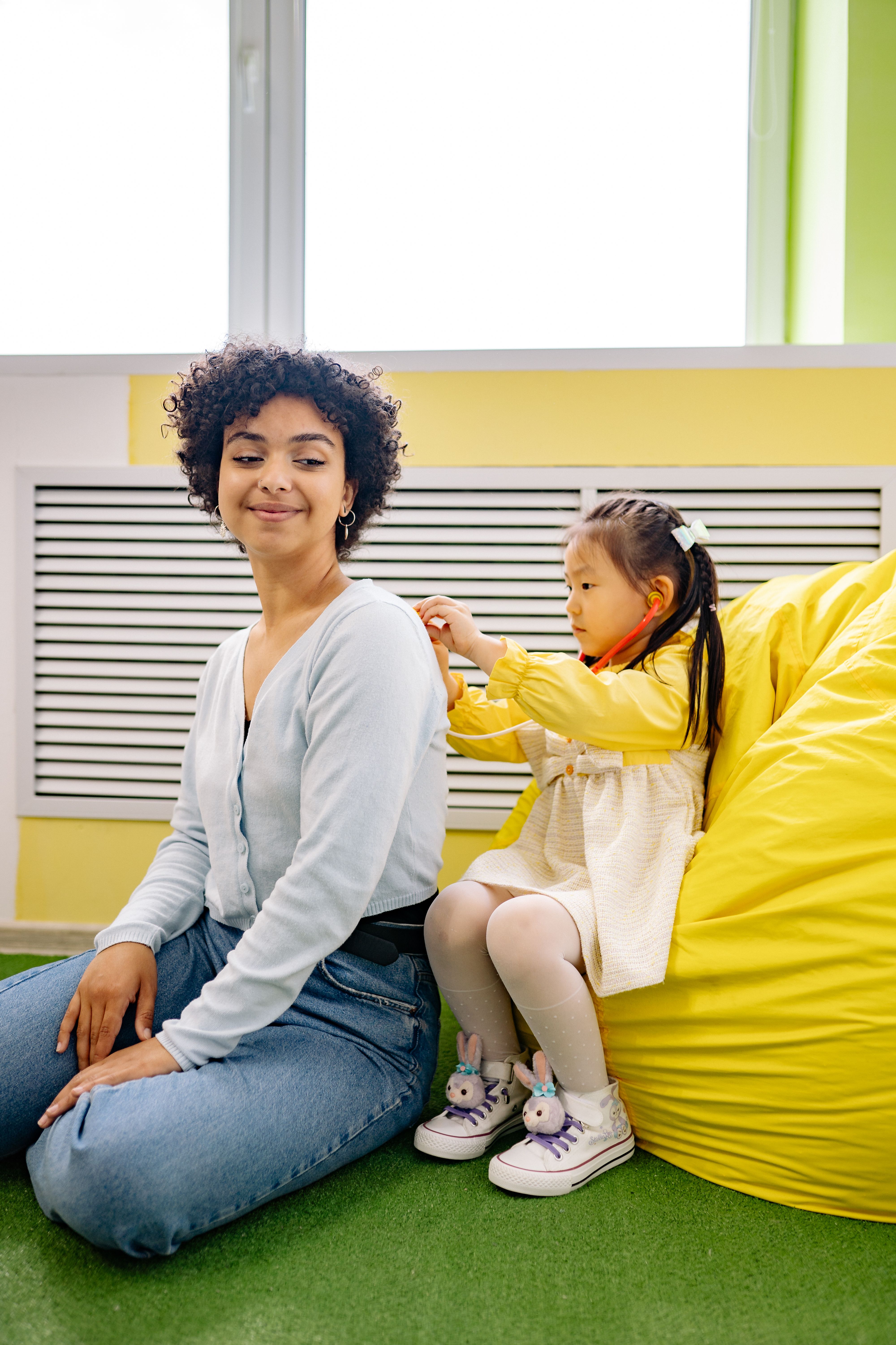 Caregiver playing with child in a calm playroom