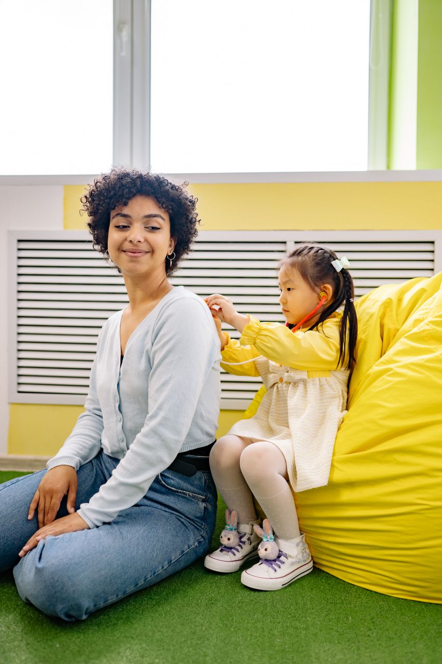 Caregiver playing with child in a calm playroom