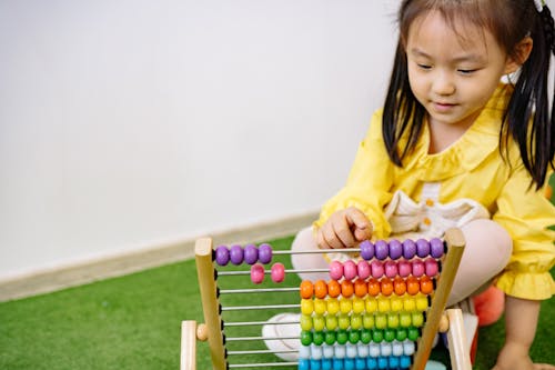 Girl in Yellow Dress Playing With Abacus