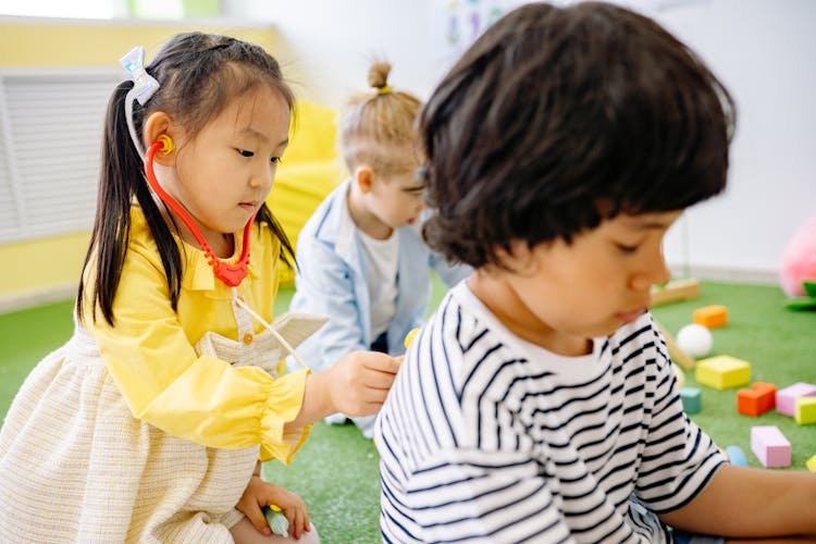 Girl In Yellow Dress Playing Doctor To Her Classmate