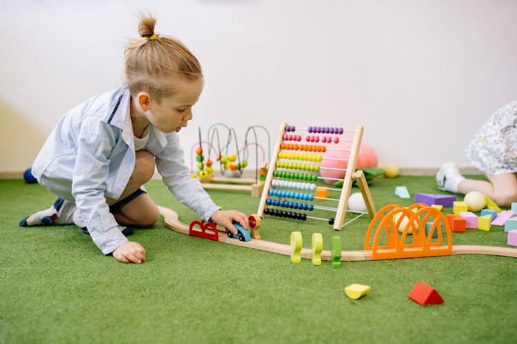 Boy Playing With Wooden Toy Car