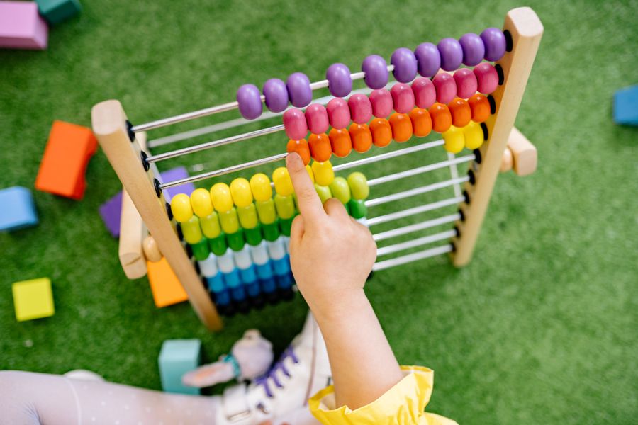 Child learning to count with a colorful wooden abacus