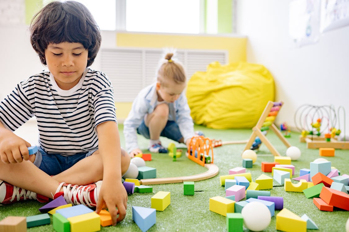 Free Two Boys Playing With Wooden Blocks in a Room Stock Photo