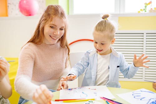 Free Girl Learning To Paint With Her Teacher Stock Photo