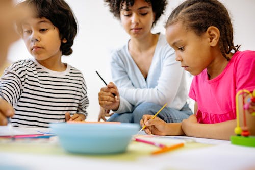 Free Woman and Two Kids Sitting at Table Painting Stock Photo
