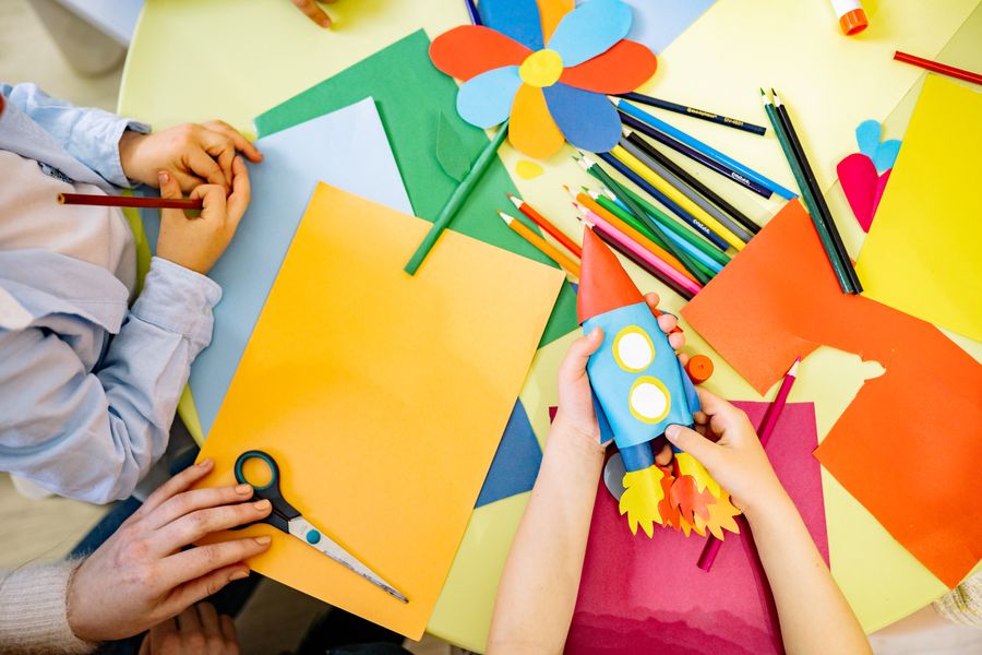 Mesa de artes com papéis e lápis coloridos