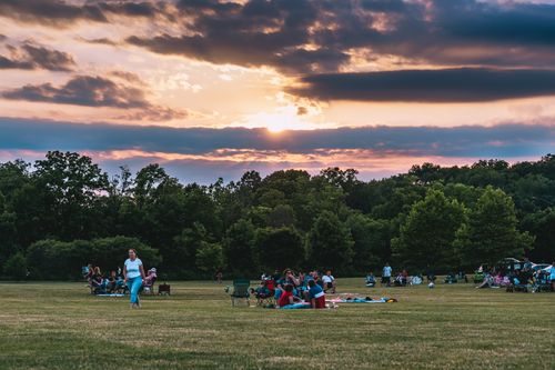 Free People enjoying a tranquil picnic during sunset in a beautiful park setting. Stock Photo