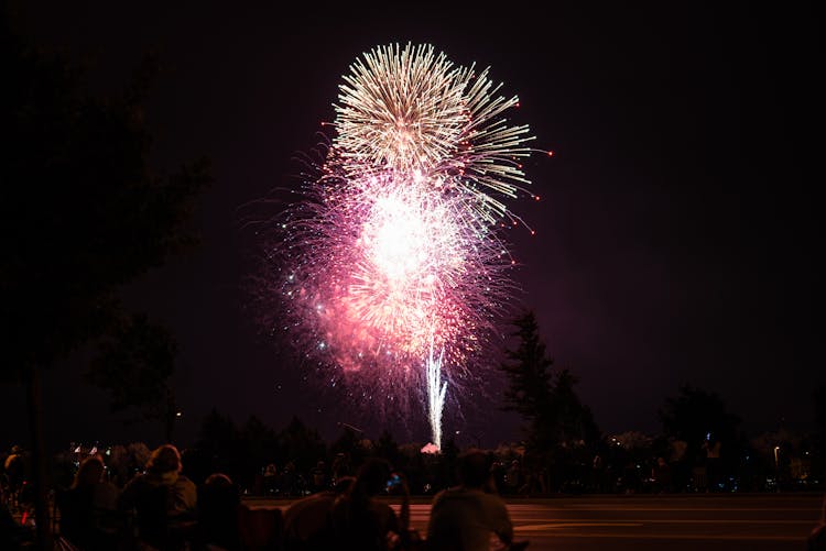 People Watching Fireworks Display At Night 