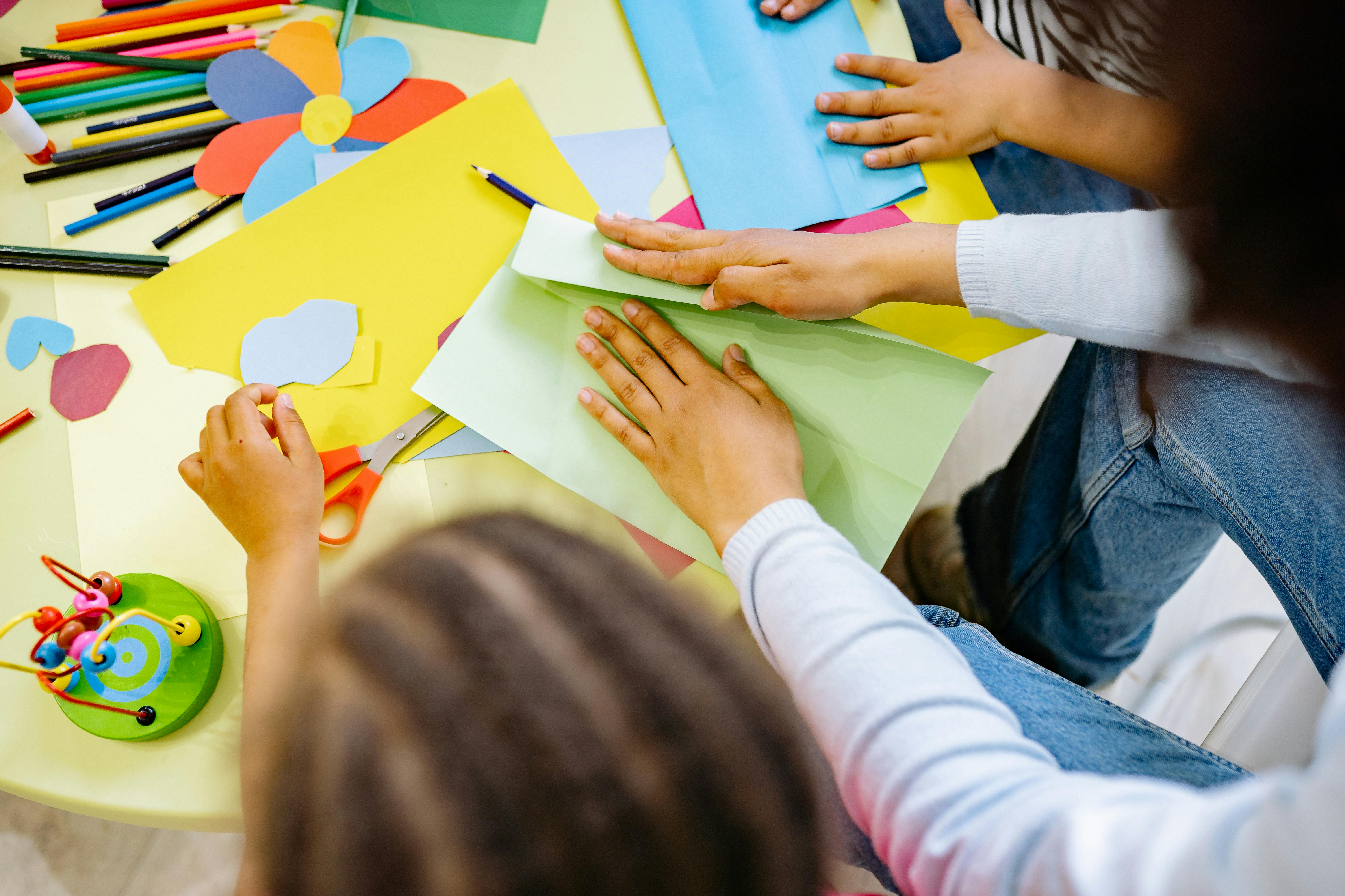 woman and children doing art with colored papers