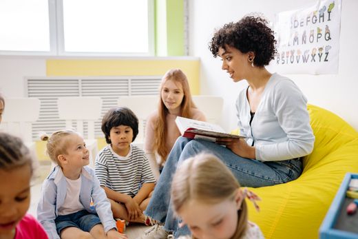 Teacher reading a story to preschool children during morning circle