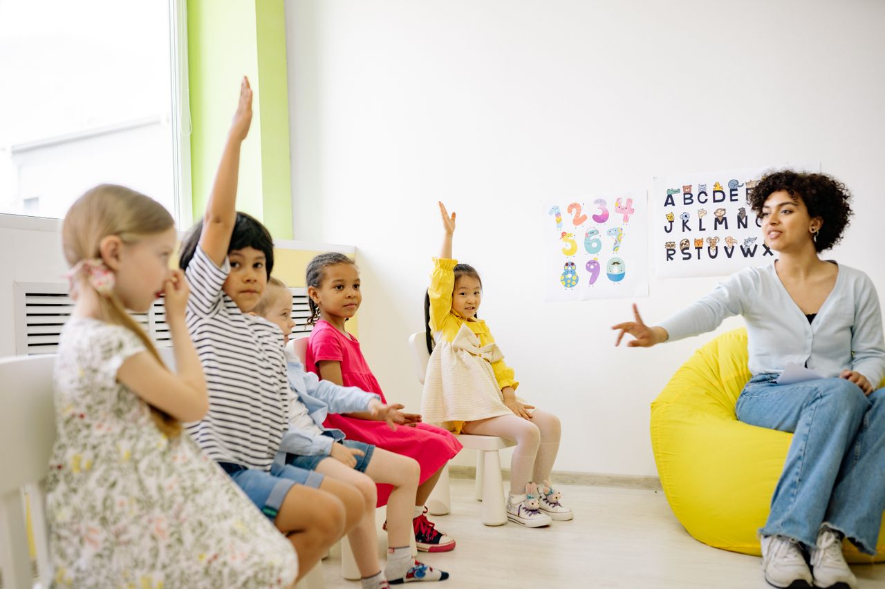 interactive-bulletin-board-classroom Students raising hands and engaging in a classroom activity