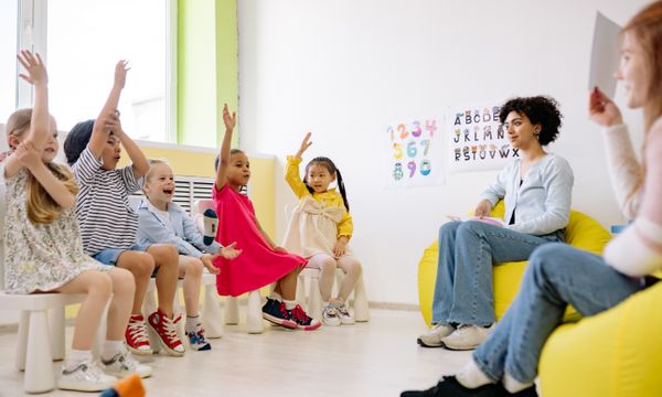 Crèche & Daycare Support — Children actively participate in a classroom with teachers, showcasing diversity and engagement.