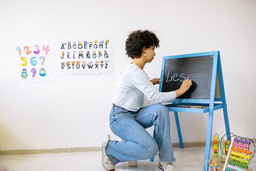 African American teacher writing on small blackboard in a lively classroom setting.