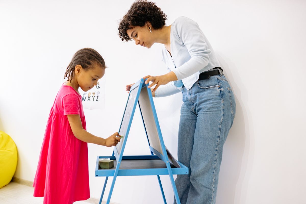 Child and teacher at a small easel board