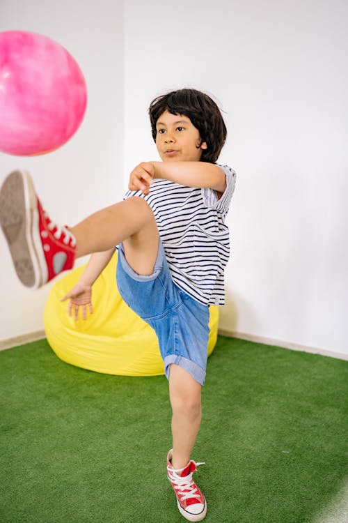 Boy in Black and White Striped Shirt Playing With Pink Balloon