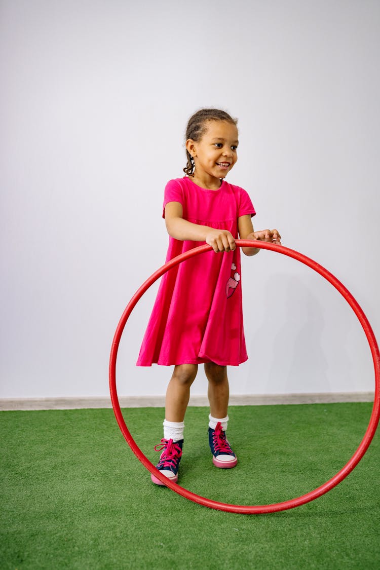 Little Girl In Red Dress Holding Red Hula Hoop