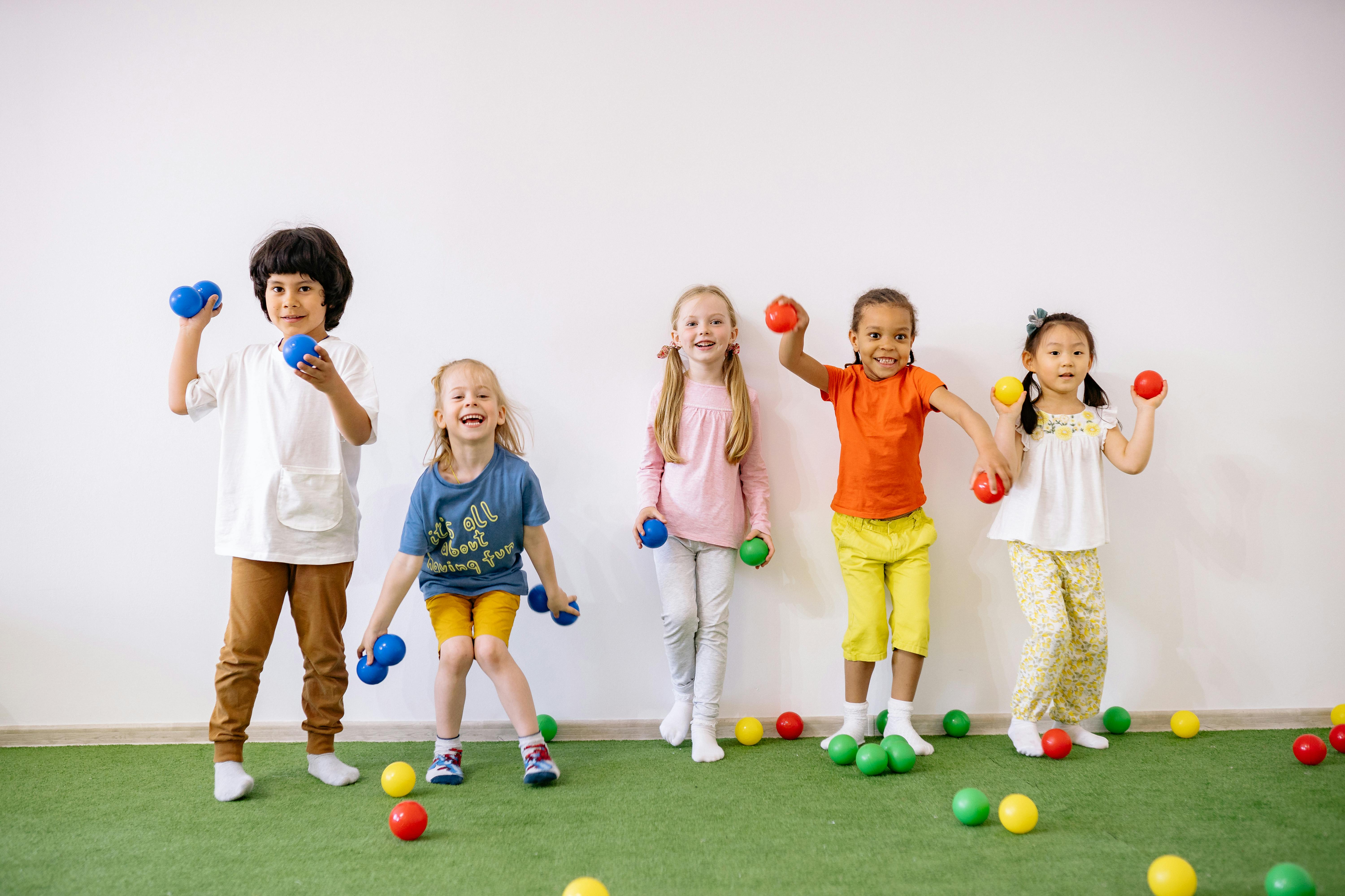 little girls and boys having fun playing with colorful balls