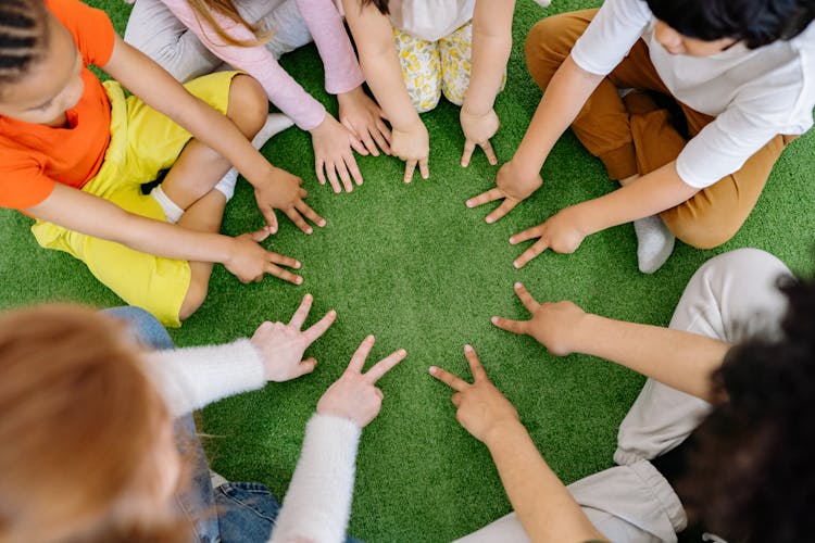 Group Of Children Playing On Green Grass 