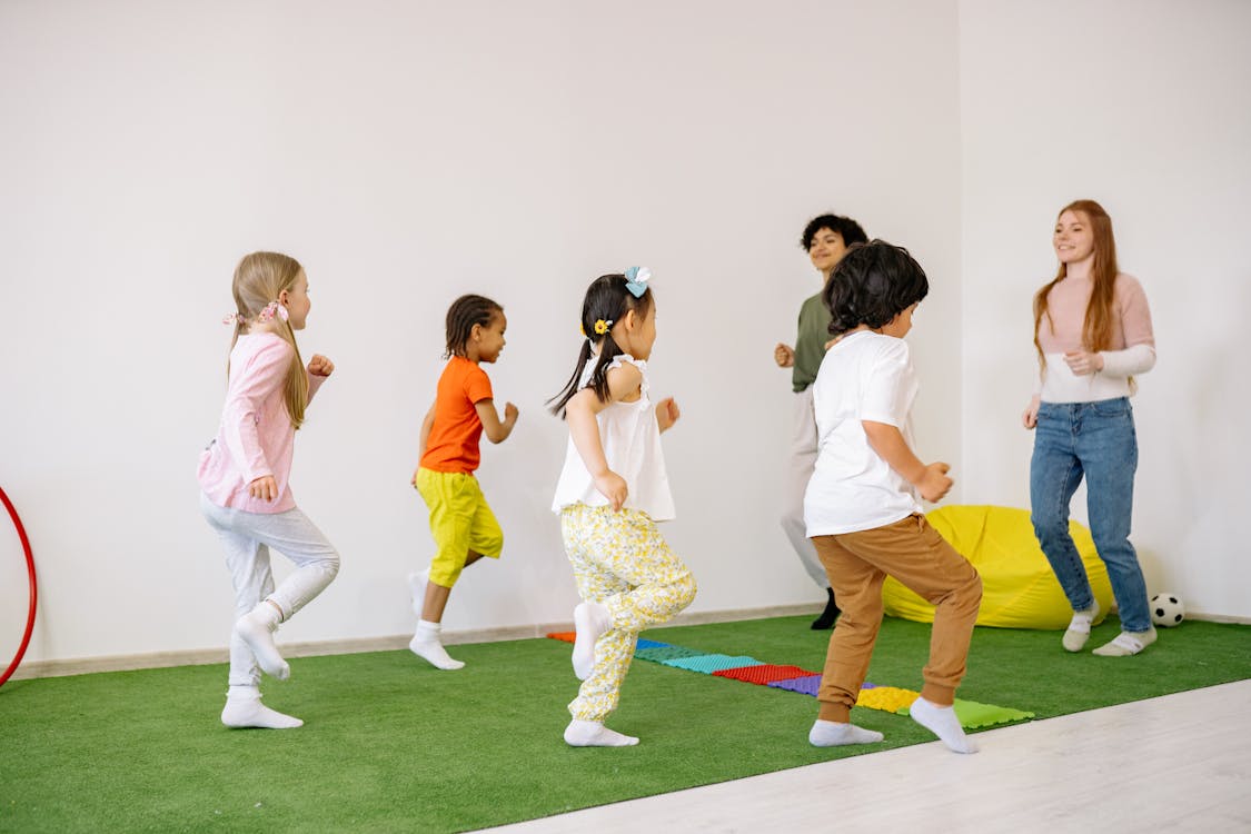 Free Preschoolers Doing Running Exercise With Their Teachers Stock Photo
