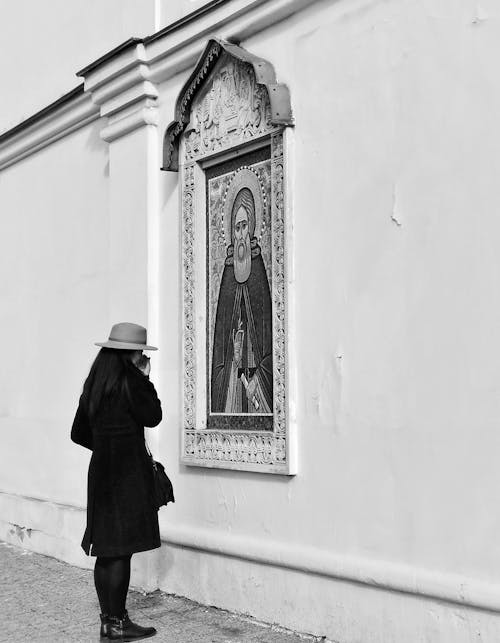 Woman in Black Coat Standing in Front of a Painting