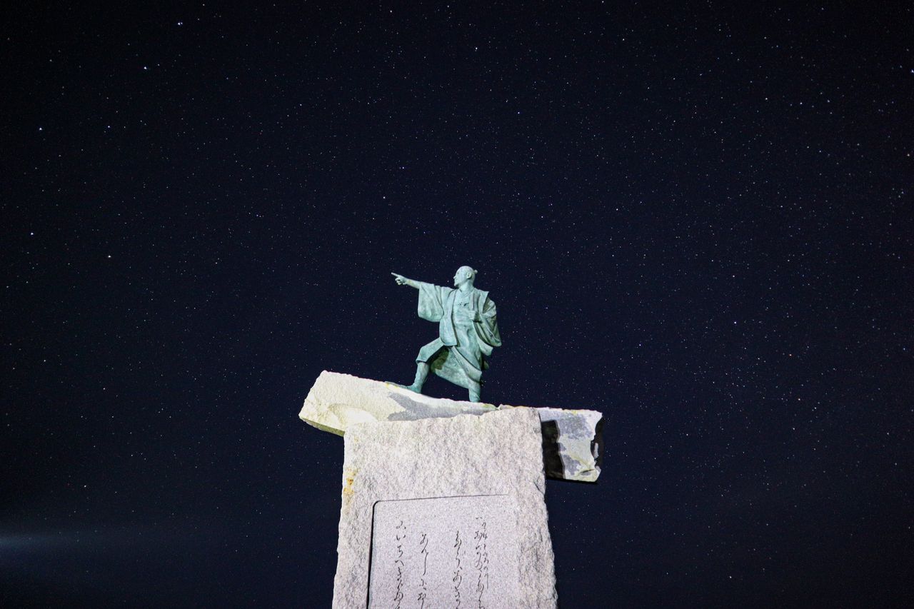 the taiki statue at cape zanpa pointing under a starry night sky in ja