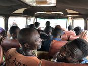Interior view of a crowded bus with diverse passengers in Kumasi, Ghana.