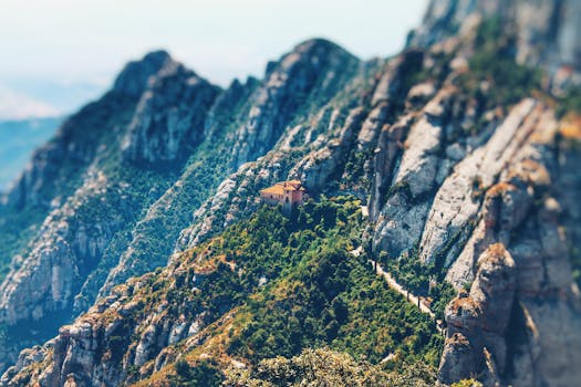 Breathtaking view of a mountain landscape with a lone building nestled among rocky peaks.