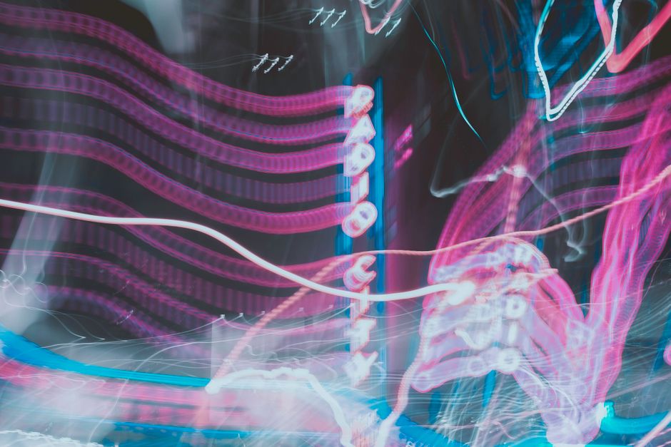 Abstract image of neon lights and signs at Radio City, showcasing vibrant colors and motion blur.