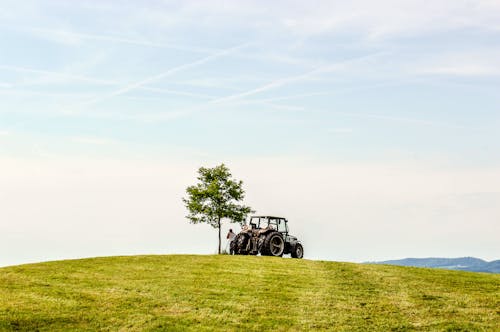 Free A Man and a Tractor on Top of a Hill Stock Photo