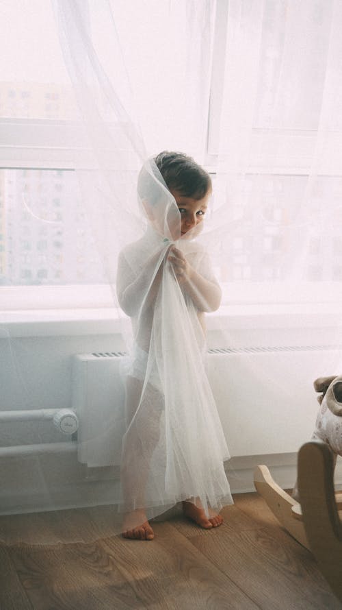 Cute Toddler Hiding Behind the Curtain