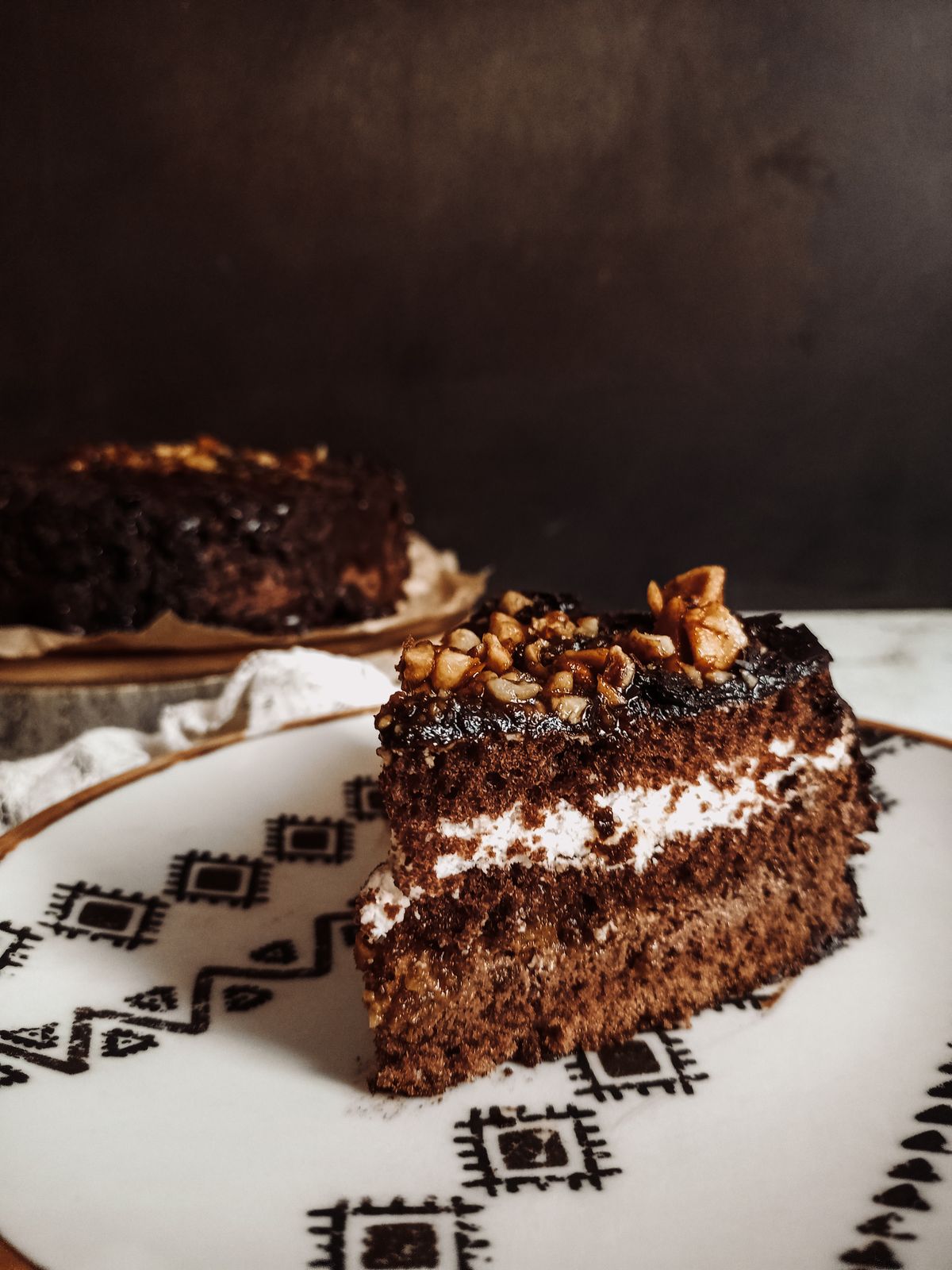 Fetta di torta al cioccolato con frutta a guscio; fotografia illustrativa