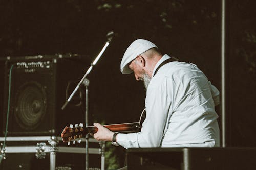 Man in White Long Sleeve Shirt Playing Guitar