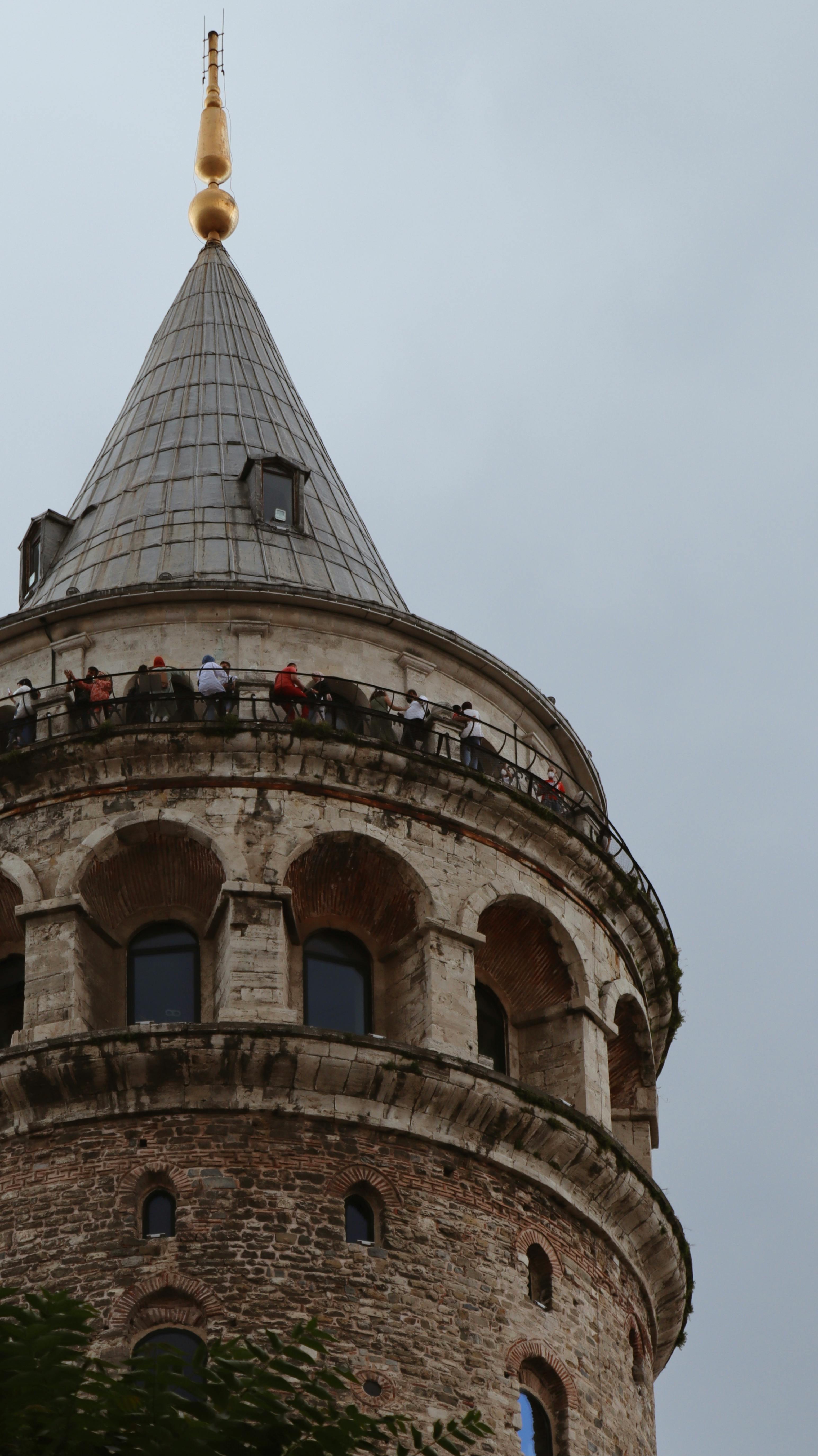 Captivating view of Galata Tower's top section with visitors enjoying the landmark in Istanbul.