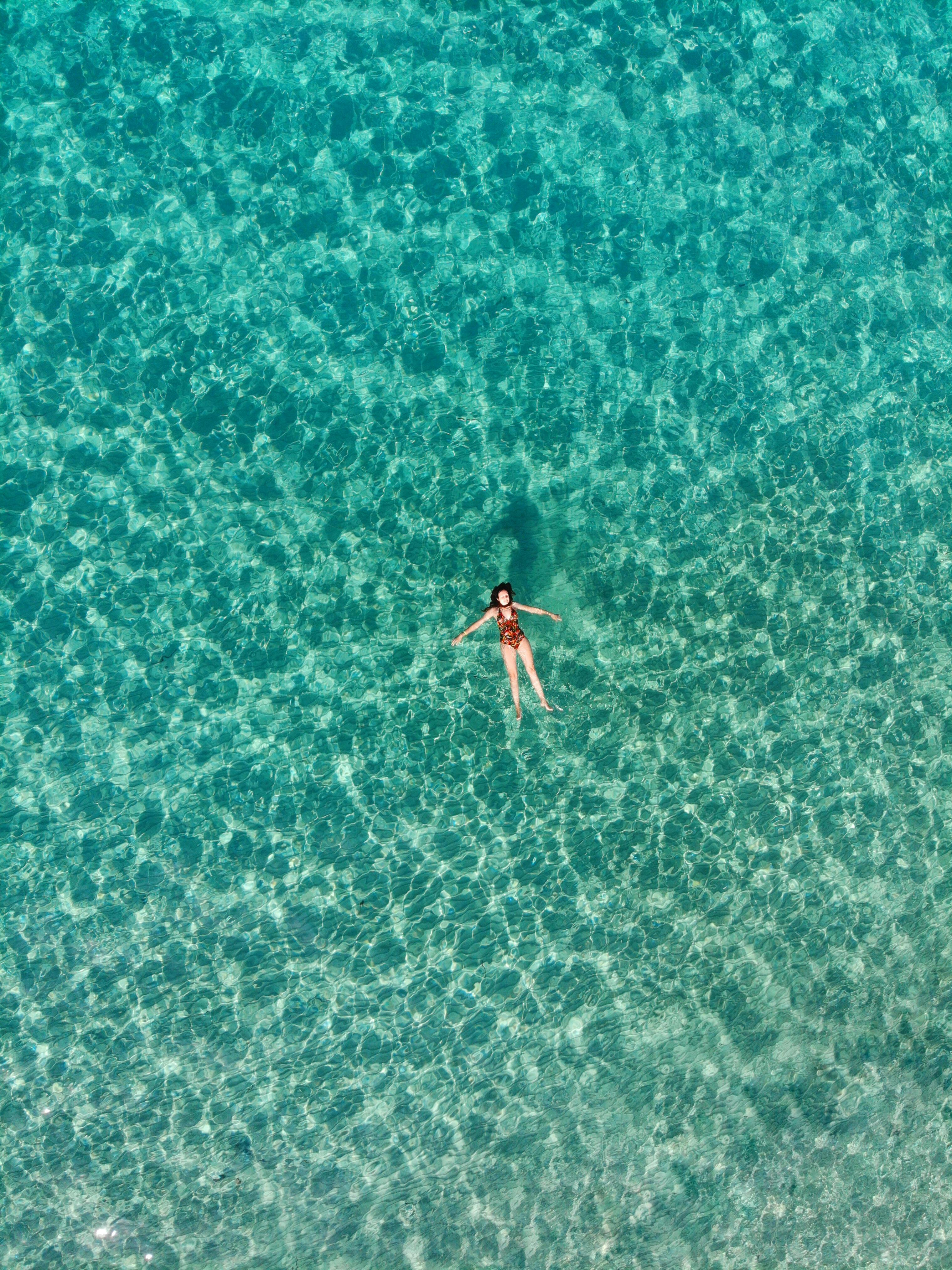 Woman in Blue Bikini Floating on the Sea · Free Stock Photo