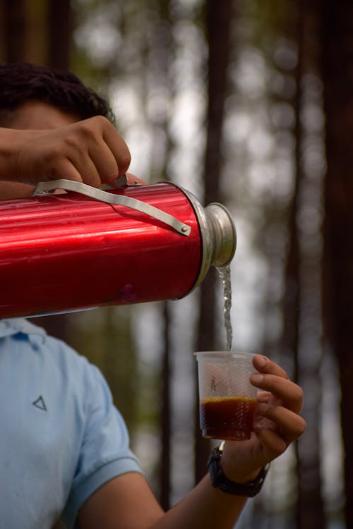 Person Pouring Hot Water into a Plastic Cup