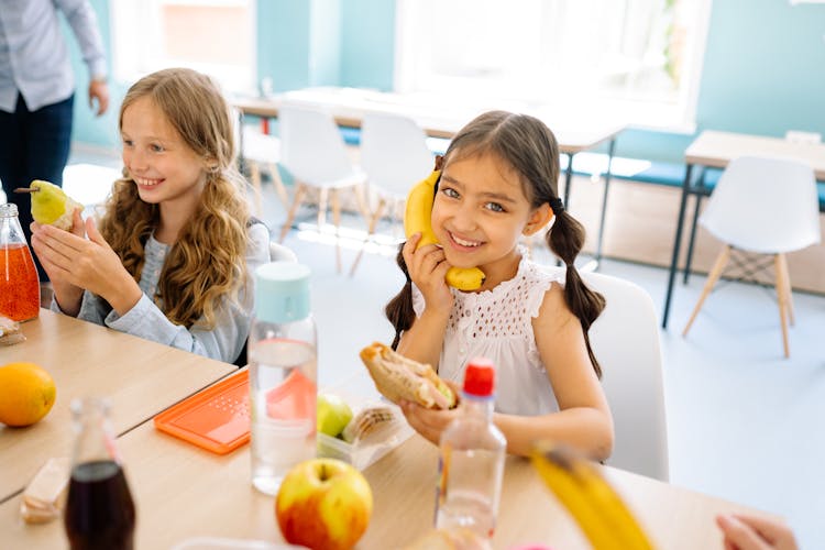 Girls Smiling While Eating Snack During Their Break Time