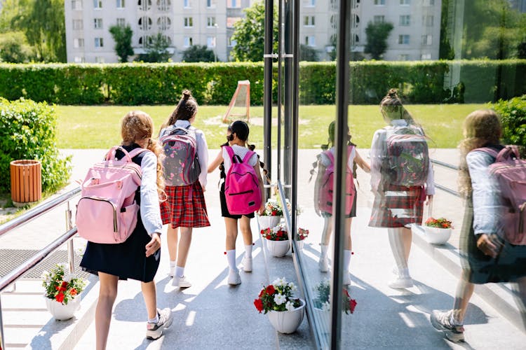 School Girls Walking While Carrying Their Bags