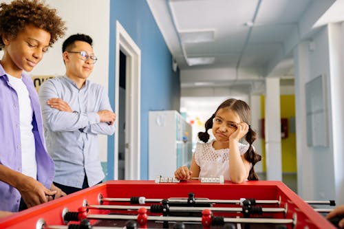 Free Kids Playing Foosball in the Classroom Stock Photo