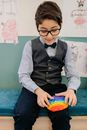 Boy in Gray Long Sleeve Shirt and Black Vest Sitting on Blue Bench
