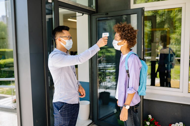 A Teacher Checking His Student's Temperature